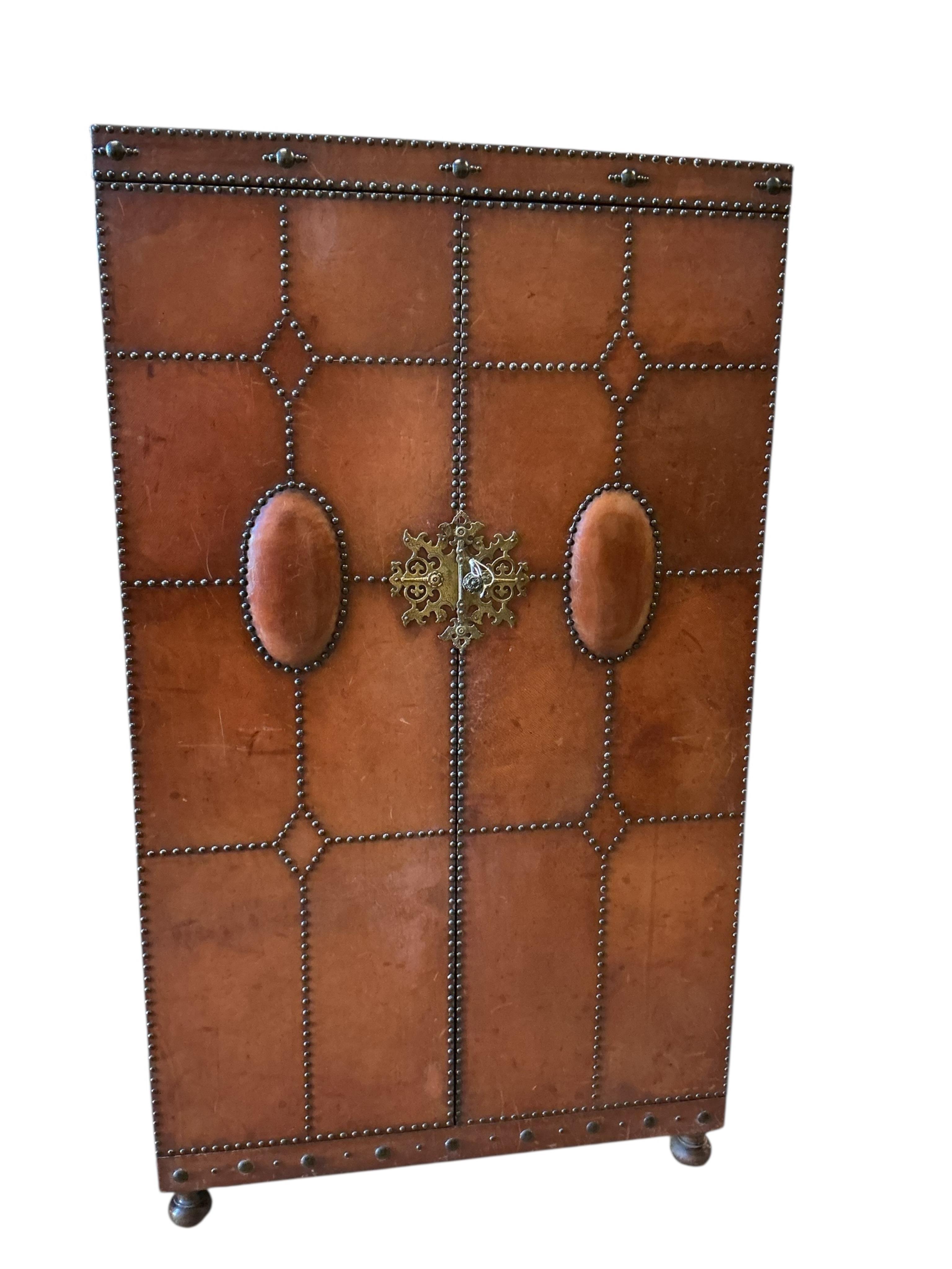 An early 20th century Spanish style studded, tan leather covered two door wardrobe, width 96cm, depth 46cm, height 168cm